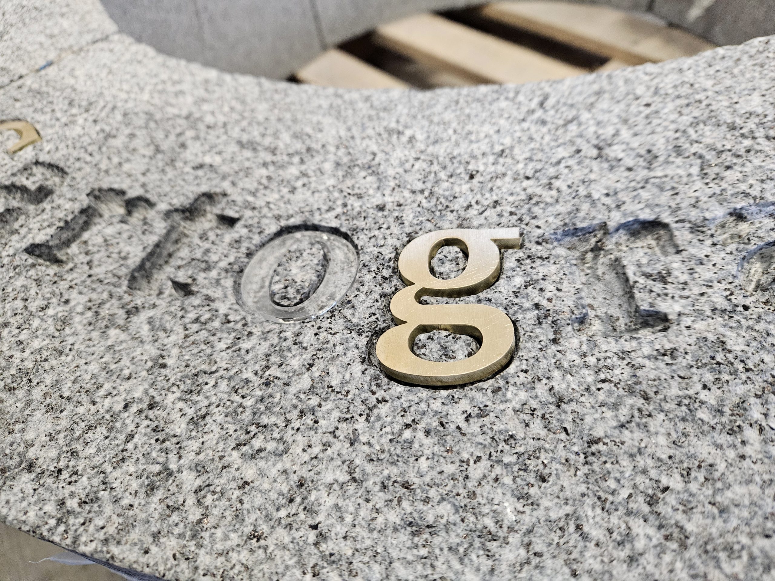 Gravure sur bordure en granit breton conçue pour l’insertion de lettres en laiton à Saint Helier, Jersey